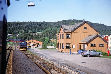 Norwegian State Railways diesel multiple unit locomotive no. 9253 approaches a station and its arrival captures the attention of an onlooker in Snåsa, Nord-Trøndelag, Norway, on June 7, 1989. This photograph is taken as the photographer travels the areas of Nordland and Sør-Trøndelag, Norway. Photograph by Fred M. Springer, © 2014, Center for Railroad Photography and Art. Springer-Scan-Swiss-York-08-14