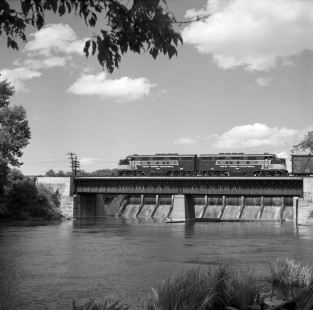 A westbound New York Central (NYC) freight train crosses a bridge over the Huron River in Ann Arbor, Michigan, circa 1950. The Barton Dam is visible behind the bridge. Photograph by Robert A. Hadley. © 2016, Center for Railroad Photography and Art