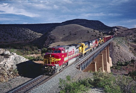 Five modern diesel-electric locomotives pull a Santa Fe freight train across a bridge in Abo Canyon, New Mexico, on June 29, 1995. Photograph by Fred M. Springer, © 2016, Center for Railroad Photography and Art. Springer-TX6-20-04