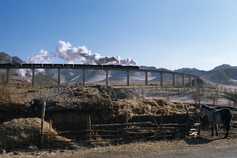 Jitong Railway QJ-class locomotives lead eastbound freight over Simingyi Viaduct, west of Hadashan, Inner Mongolia, China, on November 14, 2002. Photograph by Katherine Botkin. BOTKINK-103-KT-110, © 2002, Katherine Botkin
