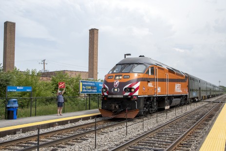 Heidi Raia holds up a Milwaukee Road E unit herald as Metra engineer John Appel makes his last run after 52 years of railroad service, at Mayfair Station in Chicago, Illinois, on June 29, 2020.