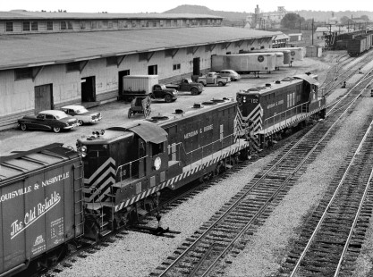 Meridian and Bigbee Railroad freight train pulls past Gulf, Mobile and Ohio Railroad's large freight house en route to interchange yard in downtown Meridian, Mississippi, in August 1958. Note horse-drawn wagon beside streamlined autos. Photograph by J. Parker Lamb, © 2016, Center for Railroad Photography and Art. Lamb-02-033-12