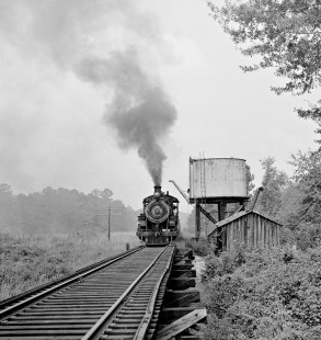 Bonhomie and Hattiesburg Southern Railroad 2-8-2 "Mike" no. 300 leads southbound freight train away from water tank in August 1958. Photograph by J. Parker Lamb, © 2016, Center for Railroad Photography and Art. Lamb-02-031-07