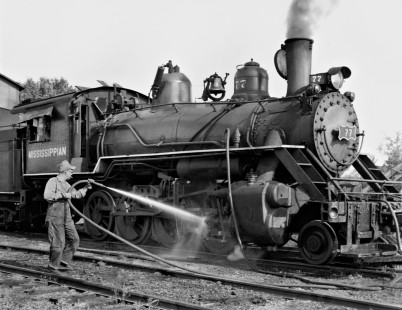 Frank Carlisle uses boiler water to clean running gear of his engine after daily run in August 1957. His brother, James, called no. 76 by the same name since they alternated useage monthly. Each would usually serve as fireman when the other was at the throttle. Photograph by J. Parker Lamb, © 2016, Center for Railroad Photography and Art. Lamb-02-028-06