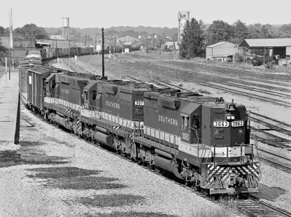 Southbound Southern Railway freight train no. 153 passes station in Meridian, Mississippi, as it heads toward the yard in April 1968. Gulf, Mobile and Ohio Railroad storage yard above locomotives. Photograph by J. Parker Lamb, © 2016, Center for Railroad Photography and Art.  Lamb-01-111-03
