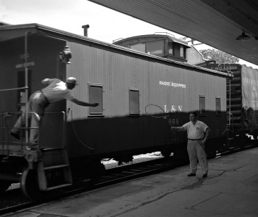 Operator at Biloxi, Mississippi, hands up orders to conductor of northbound Louisville and Nashville Railroad local train in June 1955. Photograph by J. Parker Lamb, © 2016, Center for Railroad Photography and Art. Lamb-01-137-02
