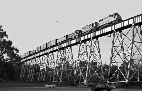 Southbound Louisville and Nashville Railroad freight train crosses Cumberland River north of Nashville, Tennessee, in August 1963, as a plane flies overhead. Photograph by J. Parker Lamb, © 2016, Center for Railroad Photography and Art. Lamb-01-143-08