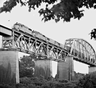Louisville-bound Louisville and Nashville Railroad train passes bird in flight during crossing of Cumberland River bridge north of downtown Nashville, Tennessee, in August 1963. Photograph by J. Parker Lamb, © 2016, Center for Railroad Photography and Art. Lamb-01-143-05