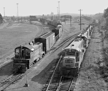 Inbound Louisville and Nashville Railroad extra freight train from Louisville, Kentucky, pulls past Radnor Yard hump switcher in early morning at Nashville, Tennessee, in August 1963. Train is en route to receiving yard. Photograph by J. Parker Lamb, © 2016, Center for Railroad Photography and Art. Lamb-01-142-02