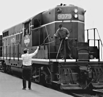 Illinois Central Railroad fireman on freight train grasping paper roll of train orders from operator at an unknown station in central Illinois in 1960. Photograph by J. Parker Lamb, © 2015, Center for Railroad Photography and Art. Lamb-01-033-01