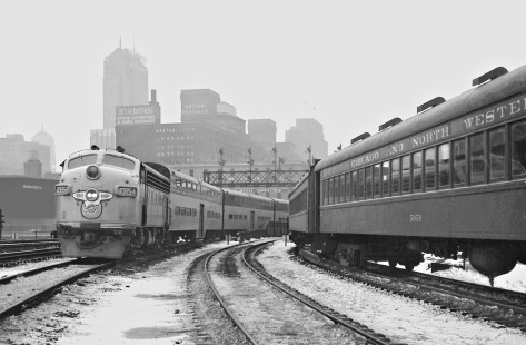 Outbound Chicago and North Western passenger train of bi-levels passes train of older passenger cars near station in Chicago, Illinois, on March 9, 1960. Photograph by J. Parker Lamb, © 2015, Center for Railroad Photography and Art. Lamb-01-058-04