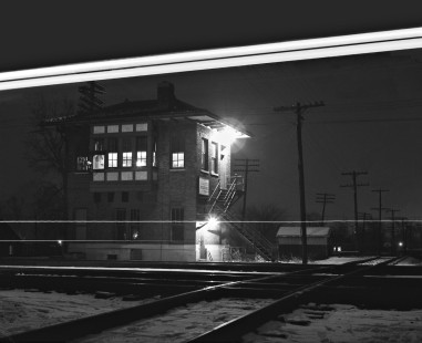 The tower at Champaign, Illinois, is framed by the headlights from a southbound Illinois Central train leaving the yard on December 20, 1959. Peoria & Eastern trackage is in the foreground. Photograph by J. Parker Lamb, © 2015, Center for Railroad Photography and Art. Lamb-01-031-11
