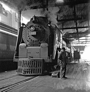 A Wabash Railroad engineer stands next to his steam locomotive, 4-6-4 no. 702, under the trainshed at Chicago’s Dearborn Station on February 2, 1952. They have just brought eastbound train no. 10, the <i>Banner Blue</i>, in from St. Louis. Photograph by Wallace W. Abbey, © 2015, Center for Railroad Photography and Art. Abbey-02-048-03