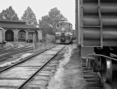 With F3 locomotive and caboose at shop in Aberdeen, North Carolina, Aberdeen and Rockfish Railroad Geep pulls past interchange cars after finishing day's run in April 1961. Photograph by J. Parker Lamb, © 2016, Center for Railroad Photography and Art. Lamb-01-094-03