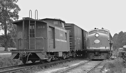 Aberdeen and Rockfish Railroad mixed train pulls into yard at Aberdeen, North Carolina, after its daily run while F3 locomotive awaits clear track to shop in April 1961. No. 303 is both a caboose and a combined baggage-passenger car. Photograph by J. Parker Lamb, © 2016, Center for Railroad Photography and Art. Lamb-01-094-02