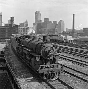Chicago’s afternoon rush is underway as Chicago & North Western 4-6-2 steam locomotive no. 514 leads a westbound suburban train on the sweeping curve just north of the North Western Terminal. Another steam-powered suburban train is visible in the distance and Fairbanks-Morse “Erie Built” diesel no. 6001B is on the far track. Photograph by Wallace W. Abbey, © 2015, Center for Railroad Photography and Art. Abbey-02-070-10
