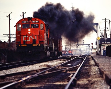 Westbound Canadian National Railway freight train led by especially smoky C630M no. 2034 in St. Lambert, Quebec, on April 26, 1980. Photograph by John F. Bjorklund, © 2015, Center for Railroad Photography and Art. Bjorklund-21-03-13