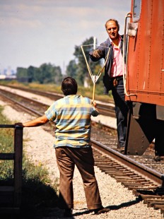 Conductor of an eastbound Canadian National Railway freight train taking orders from the operator at Tecumseh, Ontario, on September 5, 1976. Photograph by John F. Bjorklund, © 2015, Center for Railroad Photography and Art. Bjorklund-20-15-21