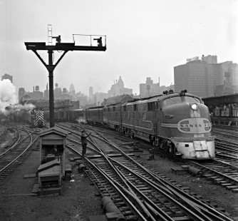 Santa Fe Railway diesel no. 11, an E3 from General Motors' Electro-Motive Corporation, leads a westbound passenger train out of Chicago's Dearborn Station on February 2, 1952. A diesel switcher and a Grand Trunk Western steam locomotive are visible in the background at left. Photograph by Wallace W. Abbey, © 2015, Center for Railroad Photography and Art. Abbey-02-046-05