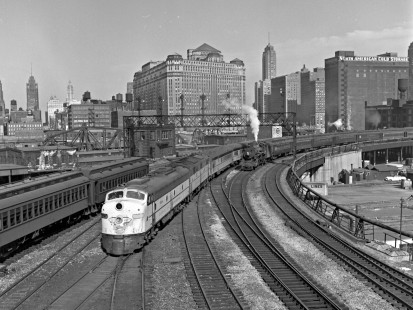 Chicago & North Western streamlined passenger train behind E8A diesel no. 5023A passes a steam-powered commuter train on the big curve just north of the the North Western Terminal in Chicago in the 1950s. Photograph by Wallace W. Abbey, © 2015, Center for Railroad Photography and Art. Abbey-02-070-12