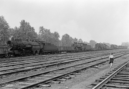 Delaware and Hudson Railway steam locomotive no. 97 and other unidentified engines sit in possible dead line at the yard possibly in Oneonta, New York, circa 1953. Alan Furler, Donald Furler's son, inspects the line. Photograph by Donald W. Furler. Furler-17-116-02; © 2017, Center for Railroad Photography and Art