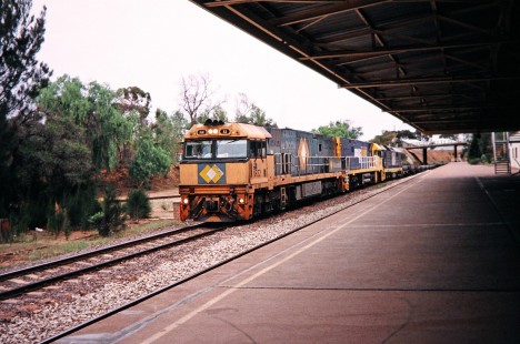 National Rail locomotive no. NR32 departing Port Augusta station in Port Augusta, South Australia, Australia, on April 12, 2003. At the time, Great Southern Rail (GSR) was contracting NR to haul its services.  Photograph by Fred M. Springer, © 2014, Center for Railroad Photography and Art. Springer-Australia-NZ(2)-01-21
