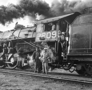 National Railways of Mexico helper crew stands in front of former Nickle Plate 2-8-2 steam locomotive no. 2209 during a climb up the grade to Zacatecas in the state of Zacatecas, Mexico on August 17, 1961. 2209 was serving as helper to NdeM 2-8-2 no. 2203 leading a southbound freight train. Rose-01-092-01; Photograph by Ted Rose, © 2018, Center for Railroad Photography and Art
