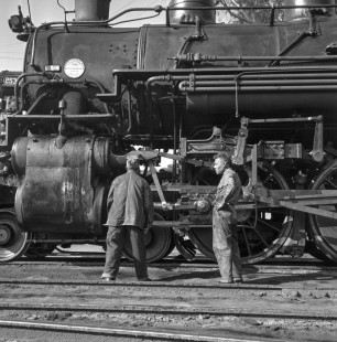 Two workers stand in front of National Railways of Mexico 4-6-2 steam locomotive no. 2530 at servicing area in Acambaro, Guanajuato, Mexico in September, 1961. Rose-01-069-09; Photograph by Ted Rose,  © 2015, Center for Railroad Photography and Art