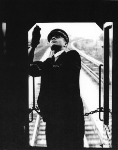 The conductor of a Chicago North Shore and Milwaukee train raises the trolley pole.