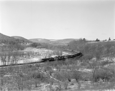 Two Erie Lackawanna Railroad cabooses bring up the rear of a freight train as it rounds a curve near Great Bend, Pennsylvania on Febuary 20, 1965. Photograph by Victor Hand. Hand-EL-30-017.JPG.