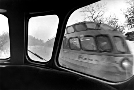 On their final day of operation, Milwaukee Road's eastbound and westbound "Afternoon Hiawatha" passenger trains pass near Wisconsin Dells on January 23, 1970. The photograph reveals an inside view of the westbound's Skytop lounge-observation car "Cedar Rapids," looking out at its sister car "Coon Rapids" on the eastbound. The trains ran daily between Chicago and Minnesota's Twin Cities.