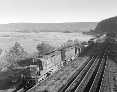 Penn Central diesel locomotives nos. 6064 and 6211, still wearing paint of predecessor Pennsylvania Railroad, haul westbound freight in Duncannon, Pennsylvania, on October 21, 1968. Photograph by Victor Hand. Hand-PRR-32-118