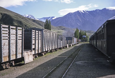 The sun sets on a train yard that holds both freight and passenger cars in Esquel, Chubut, Argentina, on October 30, 1995.  © 2014, Center for Railroad Photography and Art, Photograph by Fred M. Springer. Springer-CHI-ARG1-10-32