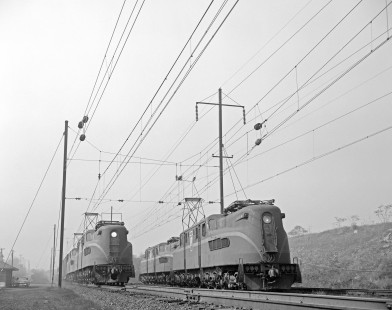 Pennsylvania Railroad GG1 electric locomotive no. 4871 hauls eastbound freight past no. 4818 in Norristown, Pennsylvania, on October 19, 1963. Photograph by Victor Hand. Hand-PRR-32-019