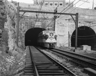 Erie Lackawanna Railroad locomotive no. 854 with eastbound train no. 1407 emerges from the east portal of the South Bergen Tunnel in Jersey City, New Jersey on June 7, 1965. Photograph by Victor Hand. Hand-EL-30-044.JPG