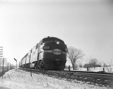 New York Central Railroad diesel locomotive no. 4028 leads eastbound passenger train no. 96, the "Dewitt Clinton," in Churchville, New York, on December 31, 1963. Photograph by Victor Hand. Hand-NYC-PC-CR-31-0023