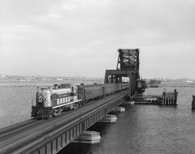 Erie Lackawanna Railroad locomotive no. 912 leads westbound passenger train no. 1167 across the Hackensack River via the HX Draw bridge at Rutherford, New Jersey on May 13, 1966. Photograph by Victor Hand. Hand-EL-30-097