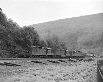 Pennsylvania Railroad diesel locomotive nos. 7106, 7195, and 7050 haul westbound freight around the Horseshoe Curve in Pennsylvania, on June 7, 1963. Photograph by Victor Hand. Hand-PRR-32-014