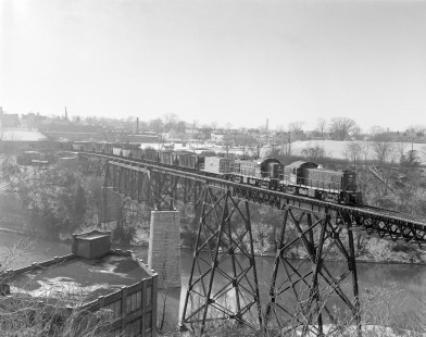 New York Central Railroad diesel locomotive no. 9901 hauls freight across a trestle in Rochester, New York, on December 24, 1967. Photograph by Victor Hand. Hand-NYC-PC-CR-31-0109