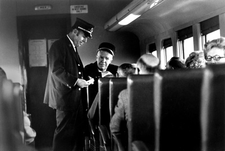 After collecting tickets, Tom Burke and Fred Loften talk with passengers on the last scheduled Milwaukee Road train from Madison, Wisconsin, to Chicago on April 30, 1971. The next day, Amtrak assumed responsibility for most of the nation's passenger service, eliminating Madison from its route map.