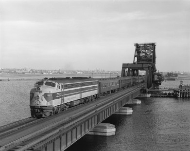Erie Lackawanna Railroad locomotive no. 813 leads a passenger train no. 1165 across the Hackensack River via the HX Draw bridge at Secaucus, New Jersey on May 13, 1966. Photograph by Victor Hand. Hand-EL-30-100