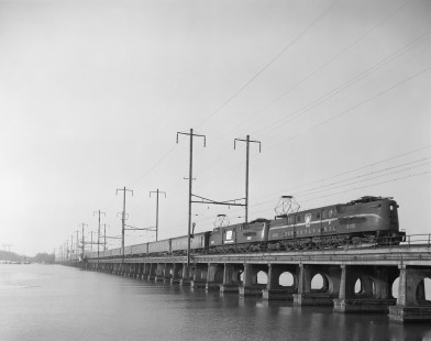 Penn Central GG1 electric locomotives nos. 4881 and 4913, still wearing the paint of predecessor Pennsylvania Railroad, lead northbound passenger train no. 144, the <i>Champion,</i> across the Bush River in Maryland, on January 4, 1970. Photograph by Victor Hand. Hand-NYC-PC-CR-31-0287