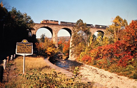 Westbound Conrail freight train with Erie Lackawanna and Penn Central power crossing Starrucca Viaduct in Lanesboro, Pennsylvania, on October 5, 1976. Photograph by John F. Bjorklund, © 2016, Center for Railroad Photography and Art. Bjorklund-56-05-05