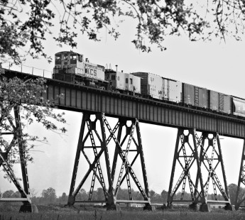 Switcher pushing heavy Kansas City Southern Railway freight train up the grade on the Mississippi River bridge at Baton Rouge, Louisiana, in February 1974. With the train near the summit, the switchman is preparing to uncouple the switcher. Photograph by J. Parker Lamb, © 2016, Center for Railroad Photography and Art. Lamb-02-072-02