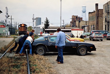 Residents of Brodhead, Wisconsin, push a Pontiac Trans Am out of the way of an eastbound Milwaukee Road freight train stopped on the Mineral Point Branch on October 22, 1978. Photograph by John F. Bjorklund, © 2016, Center for Railroad Photography and Art. Bjorklund-67-20-15