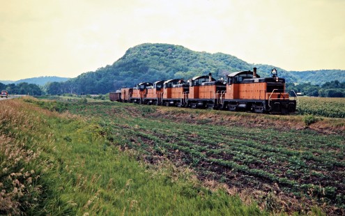 Eastbound Milwaukee Road freight train led by SW1 switchers in Rushford, Minnesota, on July 20, 1976. Photograph by John F. Bjorklund, © 2016, Center for Railroad Photography and Art. Bjorklund-65-11-18