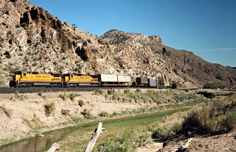 Westbound Union Pacific Railroad freight train along Meadow Valley Wash in Rainbow Canyon near Stine, Nevada, on April 10, 1989. Photograph by John F. Bjorklund, © 2016, Center for Railroad Photography and Art. Bjorklund-91-26-14