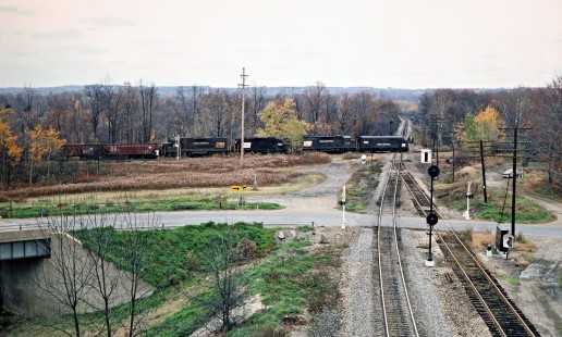 Eastbound Penn Central freight train at Erie-Lackawanna Railway crossing at Amasa Junction in Osgood, Pennsylvania, on October 26, 1975. Photograph by John F. Bjorklund, © 2016, Center for Railroad Photography and Art. Bjorklund-80-02-14