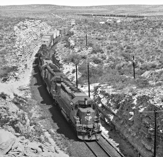 Westbound Southern Pacific Railroad stack train coils through rugged country of West Texas region near Langtry in April 1985. Photograph by J. Parker Lamb, © 2017, Center for Railroad Photography and Art. Lamb-02-082-09