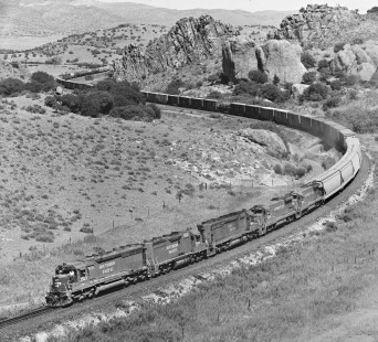 Westbound Southern Pacific Railroad manifest approaches Paisano Summit in August 1984. Man near cab was personal friend of photographer and his traveling companion. "Once he saw us perched at top of hill, he wanted to give us a wave. We often bunked in his home in Sanderson, Texas." Photograph by J. Parker Lamb, © 2017, Center for Railroad Photography and Art. Lamb-02-086-08